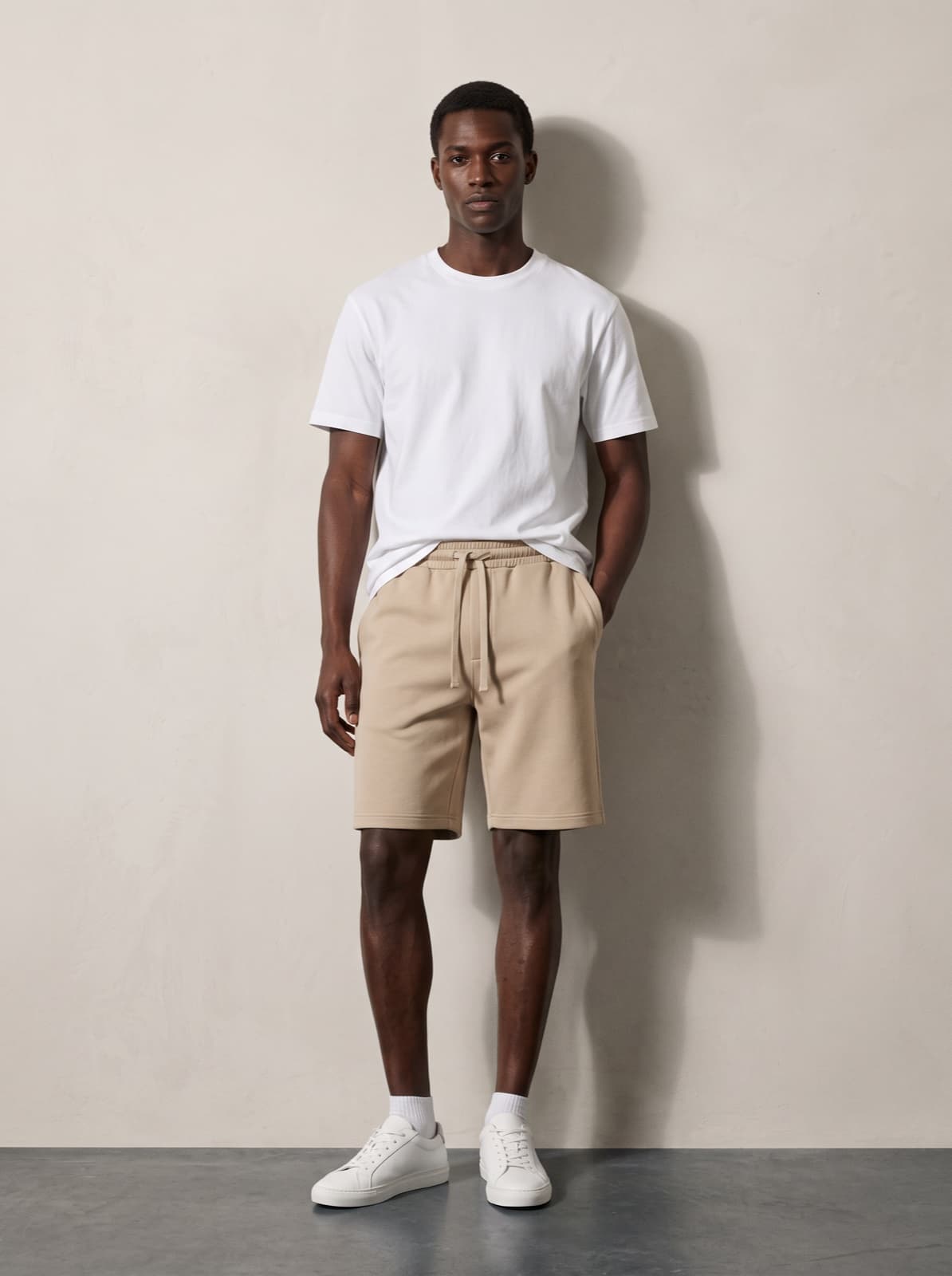 A model wearing the Chelsea Shorts in beige with a white tee
