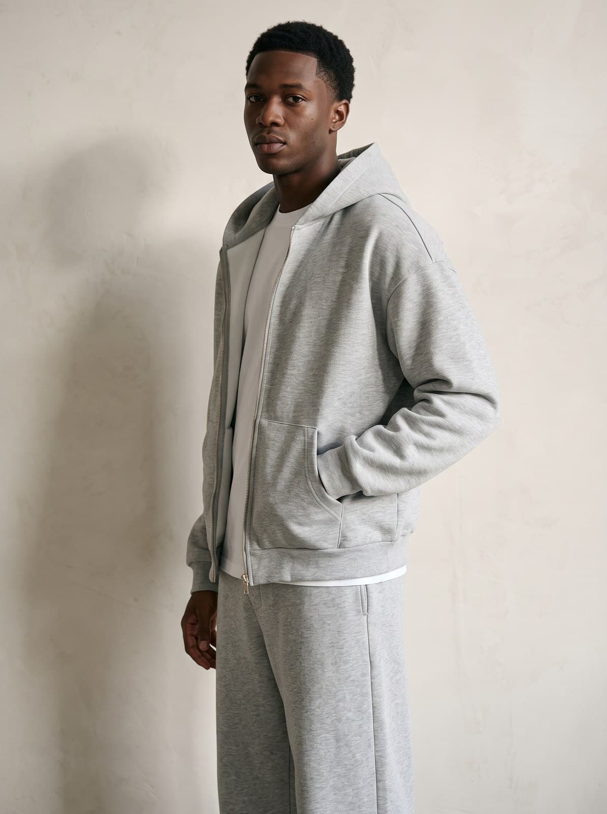 Three-quarter view of the Kensington Zip Hoodie in grey marl worn open over a white tee